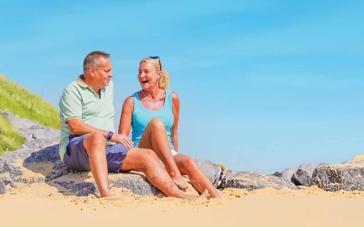 Guests enjoy a walk on the beach at Potters Resorts Hopton-on-Sea